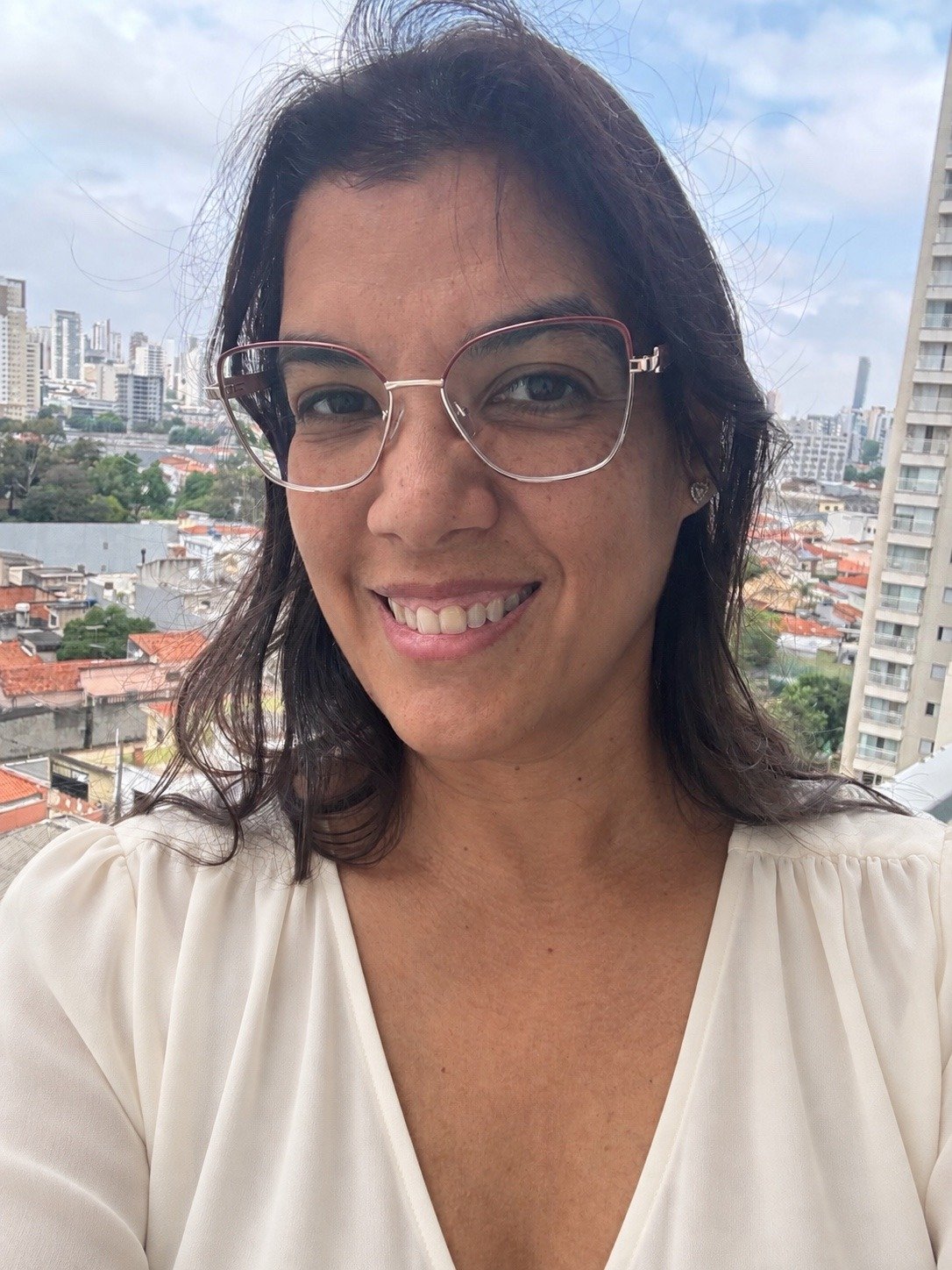 Graziela Lisboa, criadora do CR.IA, sorrindo em uma foto na varanda.